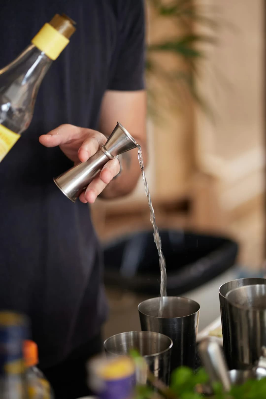 Jigger de acero midiendo liquido para coctel